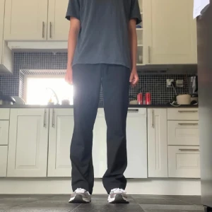 Svarta randiga kostymbyxor wide fit - Säljer ett par svarta kostymbyxor med tunna vita ränder. Byxorna har en rak och lite vidare passform. Från Filippa K.