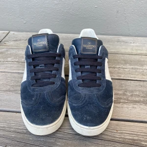 Valentino Garavani Flycrew - Tjena! Jag säljer nu mina valentino sneakers då jag har växt ur dem. Det är ett par snygga sneakers och passar perfekt för en stilig outfit nu på sommaren. Dem har tecken på användning men förövrigt ganska bra skick. Det saknas även 4 nitar. Dem är i storlek 37,5 men passar 38-39.  Hör av dig vid minsta lilla fundering eller om det önskas fler bilder, pris kan diskuteras!