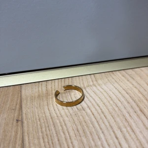 Enkel guldig öppen ring - Stilren och minimalistisk öppen ring i guldtonad metall. Ringen har en slät yta och justerbar passform tack vare den öppna designen. Perfekt för dig som gillar enkel men snygg stil. 100kr plus frakt.