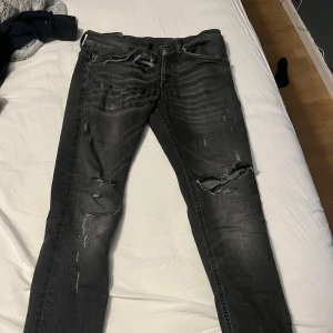 Svarta slitna skinny jeans - Säljer ett par tvär feta dondup byxor. Jätte bra skick mycket slitningar för dig som gillar sånt💯