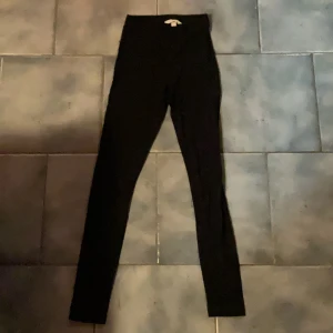 Svarta leggings från H&M XS - Svarta leggings från H&M i storlek XS. De är stretchiga och sitter tight, perfekta till oversized hoodies eller crop tops. Materialet är en mix av bomull och elastan för skön passform och rörelsefrihet.