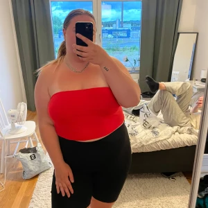 Röd bandeau tubtopp - Snygg röd bandeau tubtopp som sitter tight och ärmlös. Perfekt för varma dagar eller när du vill ha en enkel och clean look. Enkel att matcha med både jeans och kjol.