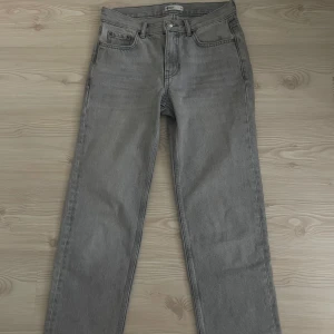 Grå lågmidjade jeans - Snygga grå jeans från Gina i klassisk rak modell. Jeansen har fem fickor, bälteshällor och stängs med knapp och dragkedja. Nyskick!