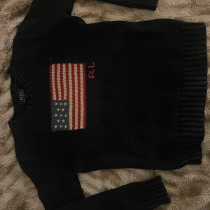 Ralph Lauren USA flaggtröja crewneck jumper - En Ralph lauren stickad tröja med USA flaggen på, storlek är XL 18-20 i barnstorlek motsvarar ungefär S skulle jag säga. Tröjan är i ny skick inga defekter eller skador alls. Passar killar och tjejer. Du är välkommen att ställa frågor :)