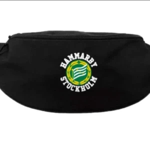 Svart magväska Hammarby Stockholm - Svart magväska med Hammarby Stockholm-logga framtill. Väskan har dragkedja upptill och är perfekt för att bära med sig det viktigaste till matchen eller på stan. Snygg och sportig accessoar för alla Hammarbyfans.