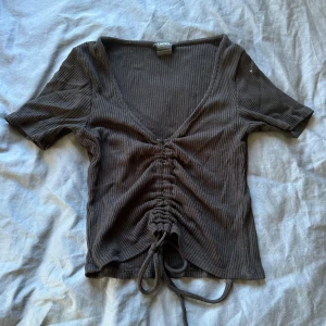 Svart ribbad topp med snörning Lindex - Svart ribbad topp från Lindex med korta ärmar och v-ringning. Storlek xs. Skriv för bild med plagget på om d önskas och pris kan diskuteras!