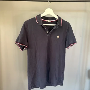 Moncler pike - Riktigt snygg Moncler piké, bra skick med mindre tecken på användning. Passar runt M. 