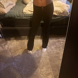 Svarta bootcut jeans från Perfect Jeans - Svarta jeans från Perfect Jeans i klassisk bootcut-modell. Snygg passform med något utsvängda ben och midja som sitter bekvämt. Jeansen är tillverkade i ett stretchigt denimtyg som ger en skön känsla hela dagen. Lite trasig i grenen. Inget märkbart. Be om bild!