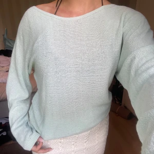 Ljusgrön stickad tröja med lös passform - Superfin ljusgrön stickad tröja med avslappnad, loose passform och långa ärmar. Tröjan har en bred, något båtformad halsringning som ger en chill vibe. Perfekt att slänga på sig över ett linne eller bikini under vår och sommar.