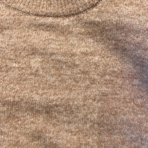 Beige stickad tröja med volang H&M - Superfin beige stickad tröja från H&M med volangdetaljer på axlarna. Tröjan har rund halsringning, långa ärmar och ribbade muddar. Perfekt för dig som gillar en söt och trendig look med extra detaljer på axlarna.