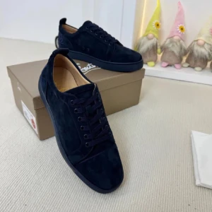 Mörkblå mockasneakers från Louboutin - Snygga mörkblå sneakers i mocka från Christian Louboutin med rund tå och platt sula. Skorna har ton-i-ton snörning och diskret broderad Louboutin-logga baktill. Insidan är ljusbeige och sulan är matchande mörkblå. Perfekta för dig som gillar stilrena och exklusiva sneakers.