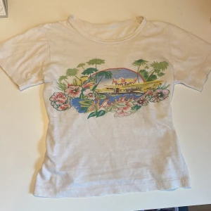 Hawaii topp - Vit t-shirt med färgglatt Hawaii-tryck framtill, med palmer, blommor och strandmotiv. Jätteskönt tunnt tyg 🫶🏼
