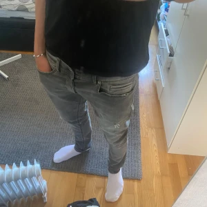 Dondup george  - Säljer ett par dondup george i grå färg med två diskreta slitningar på varsitt ben. Dem är i väldigt bra skick förutom ett litet hål i bakfickan på bild 2, men det är inget som syns igenom på något sätt.