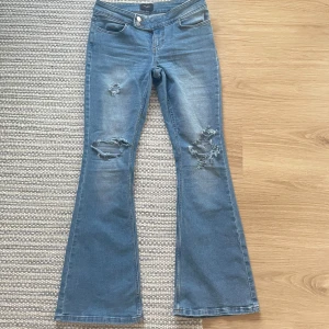 Lågmidjade bootcutjeans med slitningar  - Mycket snygga bootcutjeans som är lågmidjade och har hål vid benen. Storlek M/30 men liten i storlek så passar mer som S/30