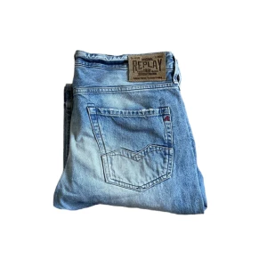 Replay waitom jeans  - Säljer ett par ljusblå Replay jeans med klassisk femficksdesign och snygga slitningar. Jeansen har raka ben och tydliga Replay-detaljer på bakfickan samt patch i midjan. Tillverkade i bomull för en skön känsla och avslappnad look. Jag skickar ej bild när jag bär plaggen och jag vet ej vilken längd och vikt de passar då jag inte prövar kläderna jag säljer 😃
