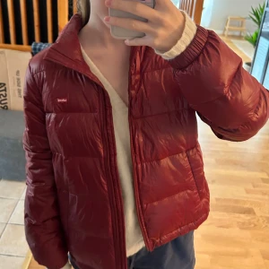 Vinröd dunjacka från Levi's - Säljer en snygg vinröd dunjacka från Levi's. Jackan har en dragkedja framtill och är perfekt för kyligare dagar. Nästan aldrig använd! Köpt för: 750kr