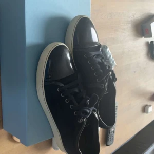 Mörkblåa Lanvins - Snygga svarta sneakers med vita sulor och snörning. Perfekta för en stilren look. Passar både till jeans och mer uppklädda outfits.