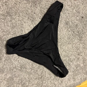 Svart bikiniunderdel - Snygg och enkel svart bikiniunderdel med en klassisk design. Perfekt för en dag på stranden eller vid poolen. Strl S men liten