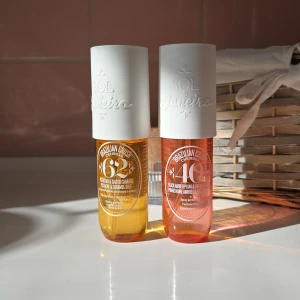 Parfymmist från Sol de Janeiro äkta!! - Två härliga parfymmister från Sol de Janeiro. Den ena har en doft av pistage och saltad karamell, medan den andra bjuder på svart bärnsten och vaniljträ. Flaskorna är eleganta med vita lock och genomskinliga behållare i gult och rosa. Perfekta för att ge en exotisk touch till din dagliga rutin. Har använts 3-4 gånger