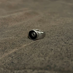 Magic 8 Ball Ring - En justerbar ring inspirerad av den klassiska Magic 8 Ball, som ger en lekfull och mystisk touch till din stil. Perfekt för den som älskar unika och kreativa smycken. Storlek US 8, justerbar.