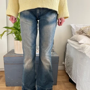 Blå bootcut jeans - Snygga blå bootcut jeans med en klassisk tvätt. De har en låg midja och en bekväm passform som ger en retro känsla. Perfekta för en avslappnad stil.