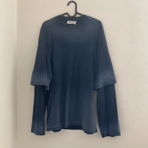 Blå långärmad tröja från Weekday - Säljer en stilren blå långärmad tröja från Weekday. Perfekt för en avslappnad look med sin mjuka och bekväma passform. Tröjan har en rund halsringning och är tillverkad i ett skönt material. Storlek XS