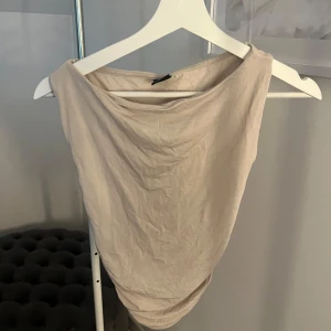 Beige topp  - Snygg beige topp med indragningar på båda sidorna. Använd fåtal gånger, jättefint skick. Skriv meddelande vid frågor/fler bilder 🩷