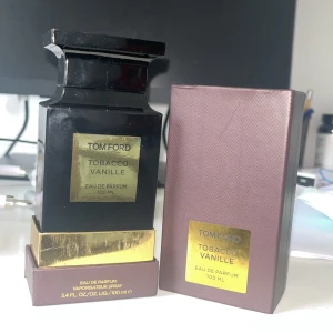Tom Ford Tobacco Vanille Eau de Parfum 100 ml - Säljer en lyxig Tom Ford Tobacco Vanille Eau de Parfum i en elegant svart flaska med gulddetaljer. Doften är en rik blandning av tobak och vanilj, perfekt för den som vill ha en sofistikerad och varm doft. Flaskan rymmer 100 ml och kommer i en stilren brun förpackning. Men såklart har jag använt den lite och så finns det runt 93-95 ML kvar. Skulle sagt att jag säljer denna hära perfymen för en ny tracksuit från under armour.