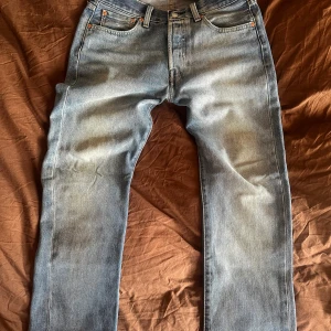 Sjukt snygga sandfadeade blå jeans Levis 501 - Säljer ett par blå jeans från Levis med en snygg tvättad look. De har en normal passform och är perfekta för en avslappnad stil. Jeansen är i nästintill nyskick. Inköpta för 1200. Storlek W30 L30. Kom med bud!