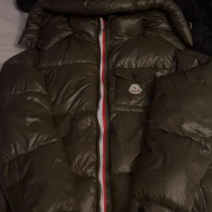 Olivgrön pufferjacka från Moncler - Säljer en olivgrön pufferjacka från Moncler. Säljer pågrund av att den är för liten och har tröttnat. Skick 9/10
