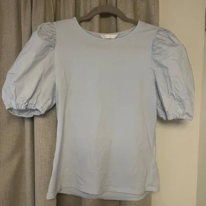 Ljusblå blus med puffärmar - Säljer en söt ljusblå blus med puffiga kortärmar!