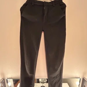 Svarta kostymbyxor från JDY - Snygga svarta kostymbyxor från JDY i en klassisk design. Byxorna har en dragkedja framtill och hällor för bälte. Perfekta för en stilren look. Kontakta mig om det är något. Köparen står för frakten 💞