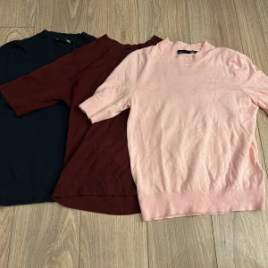 Trio av kortärmade tröjor från 157 - Säljer tre stilrena kortärmade tröjor från 157 i olika färger: marinblå, vinröd och ljusrosa. Perfekta för en avslappnad look. Tröjorna har ribbade kanter och är tillverkade i ett mjukt material. Pris kan diskuteras💞 det finns en liten rispa i ryggen på den röda tröjan💞💞