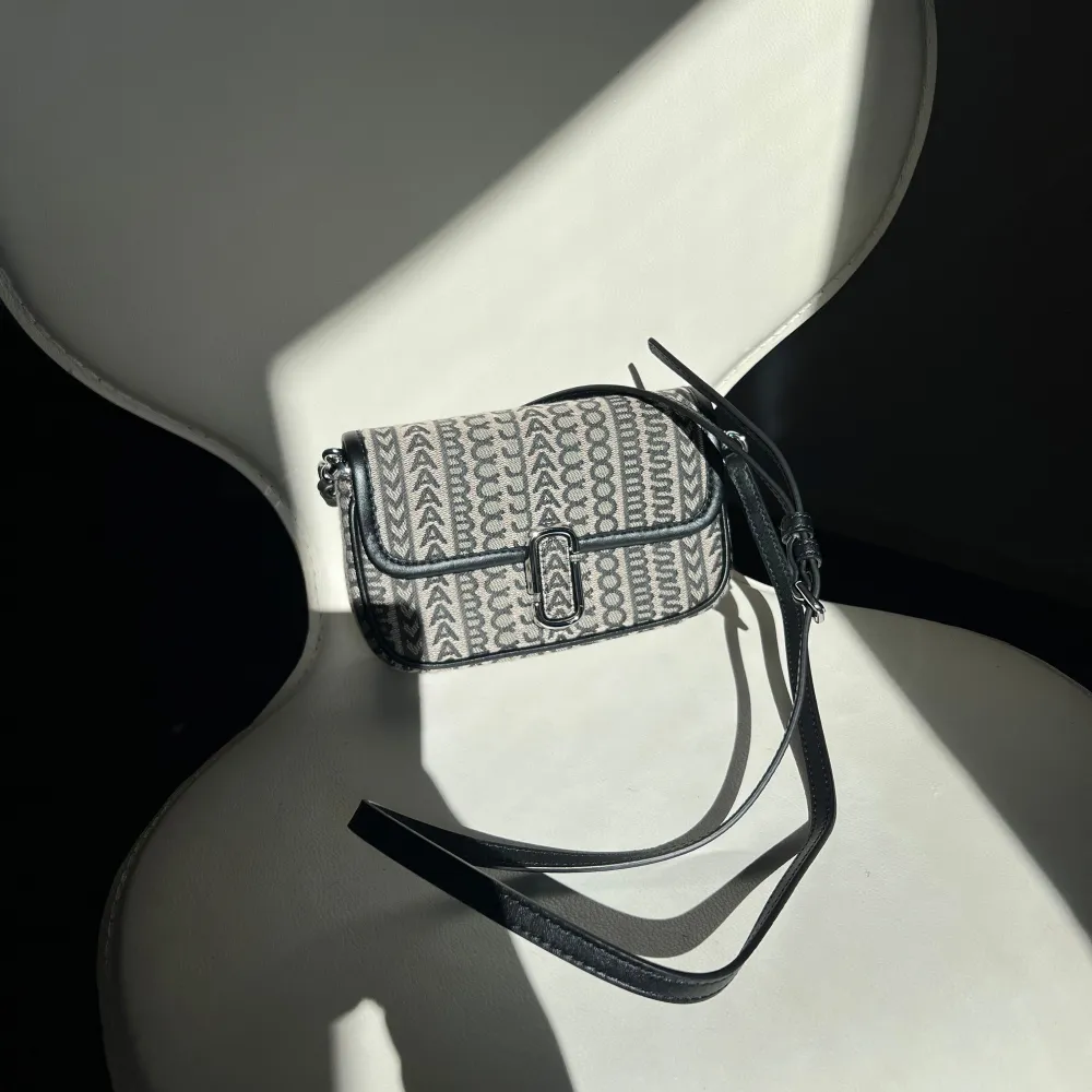 Snygg marc Jacobs väska i svart och grått. Väskan har en justerbar rem och ett spänne framtill. Perfekt för att ge din outfit en stilfull touch. Använd endast 1 gång, dustbag medkommer. . Laukut & Käsilaukut.