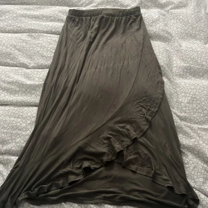 Olivgrön kjol från Jacqueline de Yong - Snygg grön långkjol från Jacqueline de Yong med omlott-design. Perfekt för en stilren look. Jag är 1,67cm för referens! Pris går att diskutera 