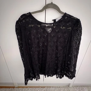 Svart spetsblus från Rodebjer - Säljer en elegant svart spetsblus från Rodebjer. Blusen har långa ärmar och ett vackert spetsmönster som ger en stilren look. Perfekt för att lyfta vilken outfit som helst. 🖤