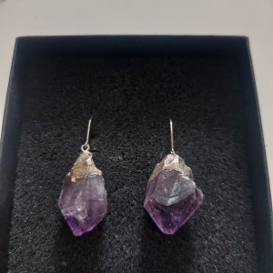 Lila örhängen med ametist - Snygga örhängen med rå ametist i lila nyans. De har en unik och naturlig form med silverfäste. 🔮