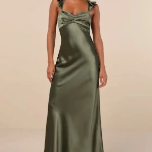 Olivgrön satin långklänning - Elegant olivgrön långklänning i satin med vackra volangdetaljer vid axelbanden. Klänningen har en öppen rygg med snörning och en smickrande passform. Perfekt för speciella tillfällen som till exempel bal💕 helt oanvänd och prislapp kvar. Säljer då jag hittat en annan klänning till balen🌸 kommer från märket Lulus och är helt slutsåld 