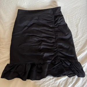 Mini kjol  - Svart mini kjol med volanger och en dragkedja på sidan