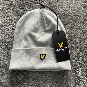 Ljusgrå mössa från Lyle & Scott - Säljer nu min helt nya Lyle&Scott mössa. Skick 10/10 aldrig använd. Storlek onesize. Skriv vid minsta fundering🙏🏻🙌