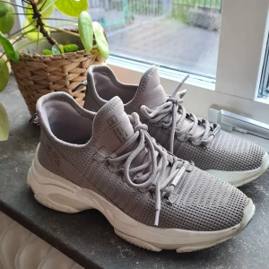 Grå sneakers från Steve Madden - Snygga grå/beiga sneakers från Steve Madden med stickad ovandel och snörning. Skorna har en tjock sula som ger extra komfort och stil. Perfekta för en avslappnad look nu tiöö vår och sommar!💐🌞