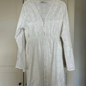 Vit klänning/studentklänning från NA-KD - Säljer en söt vit klänning från NA-KD med broderade detaljer och v-ringning. Aldrig använd!