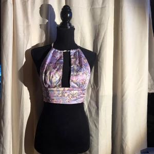 Blommig sommar topp - Säljer en blommig topp som man kan knyta både vid nacken och vid ryggen. För mig som har c/D kupa så får man lite av en side boob men den sitter ändå väldigt fint. Väldigt bra för sommaren. Köpt men knappt använd. Den är en S men gick på mig som är M 