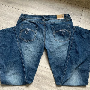  jeans - Säljer ett par klassiska blå jeans från Urban Heart med snygga kontrastsömmar och broderade bakfickor. Jeansen har normal passform och raka ben.
