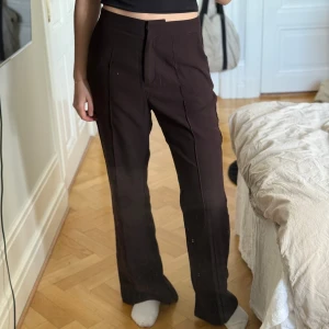 Bruna kostymbyxor från Nelly - Säljer dessa bruna kostymbyxor i storlek 36 från Nelly med slits. De är använda ett fåtal gånger och är i mycket bra skick!