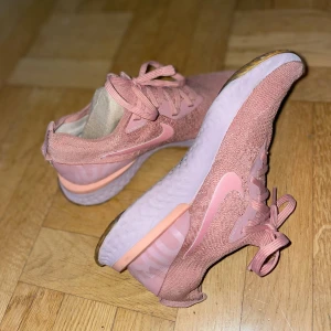 Rosa Nike sneakers - Ett par snygga rosa Nike sneakers med stickad ovandel och vit sula. Lätta och bekväma med sportig look! Passar storlek (36/37)! 🩷
