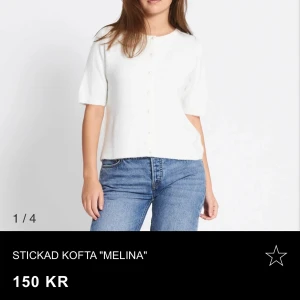 Vit stickad kofta - Säljer en vit stickad kofta med korta ärmar och pärlknappar framtill. Koftan har en rak passform och är perfekt att styla till jeans eller kjol. Enkel och stilren design som passar till många tillfällen.