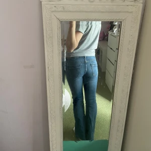 Blå  bootcut jeans - Säljer ett par klassiska blå bootcut jeans med normal passform. Jeansen är egensydda därför är priset lågt. Original jeansen är ifrån lager 157. Jeansen har fem fickor och knappar istället för dragkedja. . Perfekta till vardags och lätta att matcha med olika toppar. 