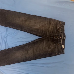 Svarta jeans från Jack & Jones - Säljer ett par svarta jeans från Jack & Jones med klassisk femficksdesign och dragkedja. Jeansen har en tapered passform och normal midja. Perfekta för dig som gillar en stilren look. Storlek (30-32)