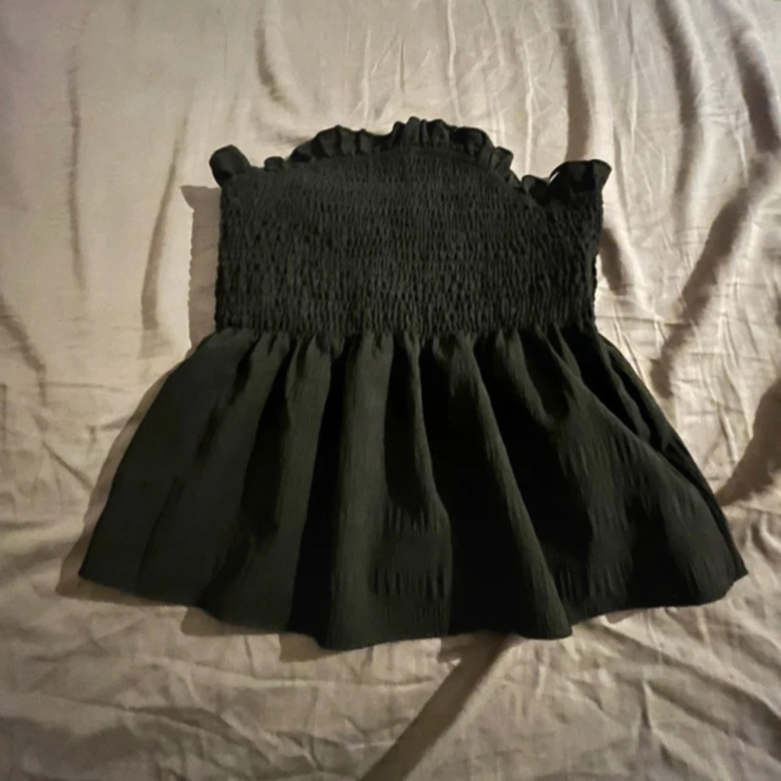 Svart smockad topp med volang